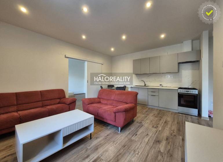 REZERVOVANÉ - Predaj, dvojizbový byt Lučenec - EXKLU... - Obývačka v 2-izbovom byte s podlahou s dreveným dekorom, červené sedačky, kuchyňa.
