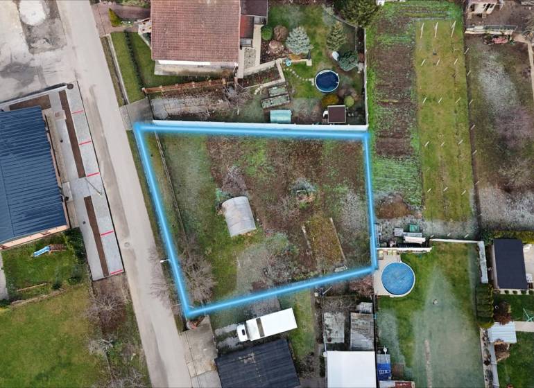 Pozemok na stavbu domu v Pate – 811 m² - bez rezervačnej zálohy - Letecký pohľad na pozemok na bývanie v Pate, ohraničený modrou čiarou.