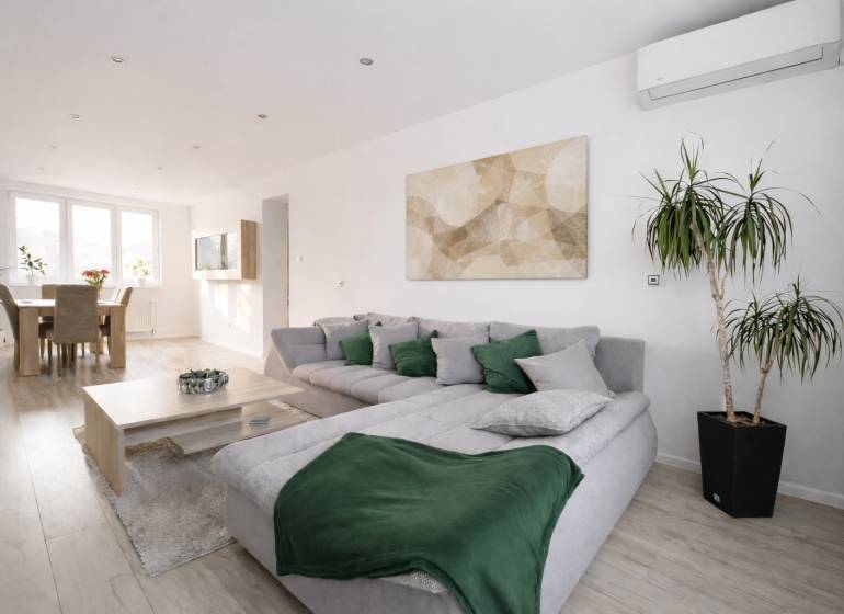 NOVINKA - Priestranných 74 m² v štýlovo zariadenom byte - Obývačka v 3-izbovom byte s podlahou s dreveným dekorom a pohodlným sedením.