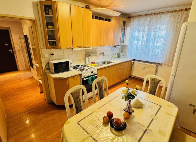 Na predaj 3 i  byt s loggiou aj terasou - Prievidza 75,24 m2 - Kuchyňa v 3-izbovom byte s podlahou s dreveným dekorom a jedálenským stolom.