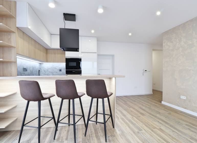 Na PRENÁJOM_v NOVOSTAVBE krásny 3-izbový byt s parkovacím státím - Kuchyňa s barovým pultom a podlahou s dreveným dekorom v 3-izbovom byte.