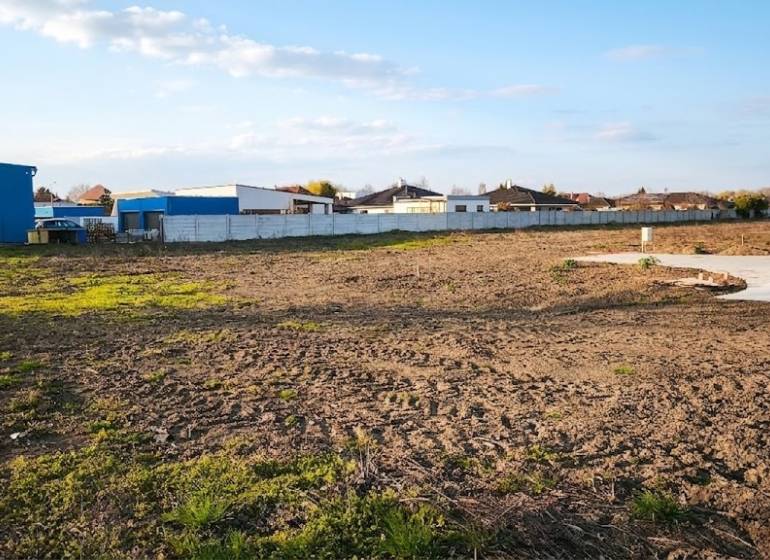 I Na predaj komerčný stavebný pozemok – Kráľová nad Váhom - Komerčné pozemky v Kráľovej nad Váhom s rozľahlou otvorenou plochou a oplotenými budovami.