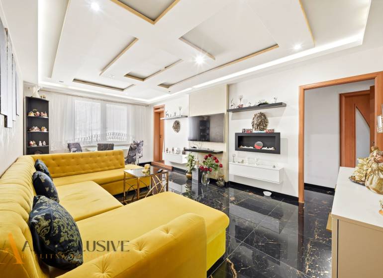 Na predaj 4-izb. byt s loggiou , Dunajská Streda - Svetlá obývačka s výrazným žltým gaučom a lesklou podlahou v 4-izbovom byte.