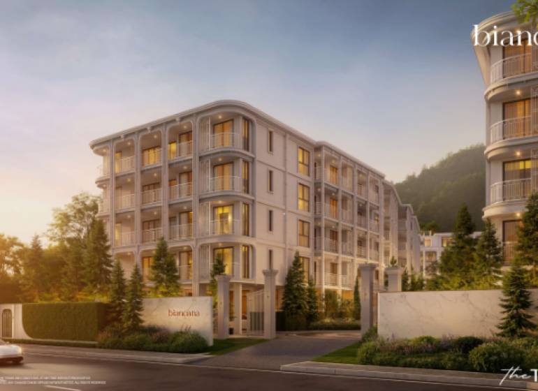 BIANCANA PHUKET - Výstavba bytov v Phuket, elegantná budova obklopená zeleňou za súmraku.