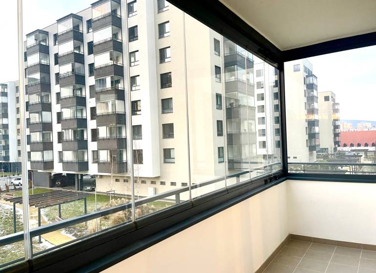 I Predaj 3i bytu v novostavbe v Rači - Zasklený balkón na Rudroffovej ulici v Bratislave, výhľad na okolité bytovky.