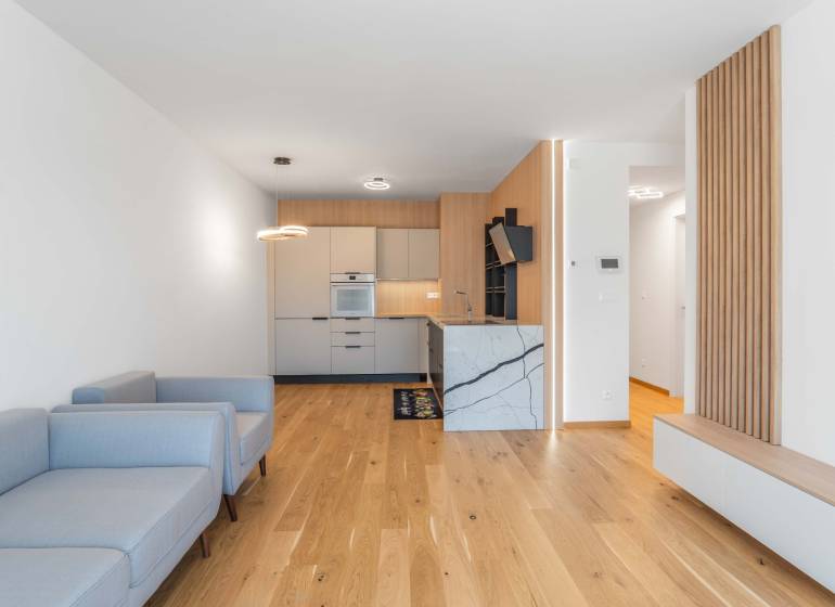 : Nadštandardný 2-i byt v projekte ZWIRN za cenu „štandardu“ - 2-izbový byt s drevenou podlahou, kuchynskou linkou a svetlými sedačkami.