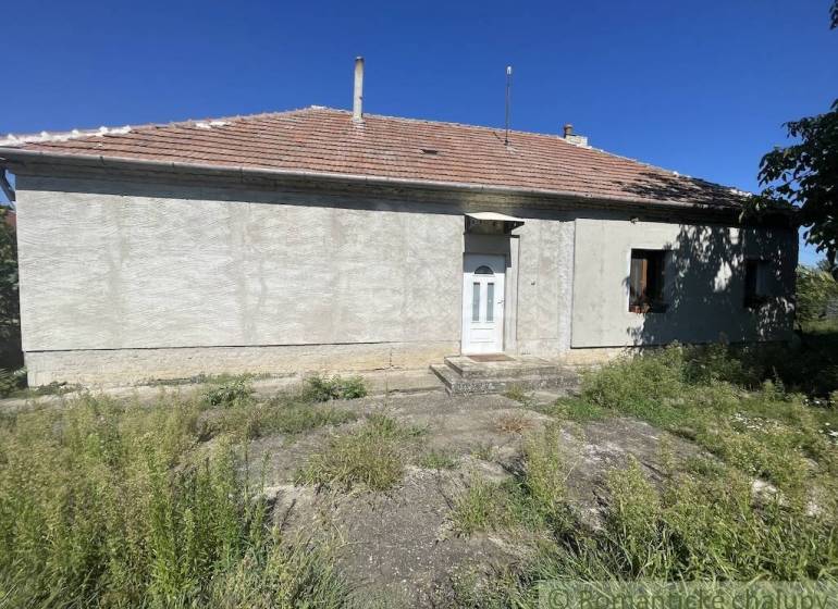 Trojizbový rodinný dom vhodný aj na chalupu v kľudnej časti obce Jatov - Rodinný dom v Jatove s jednoduchou fasádou a okolitou zeleňou.