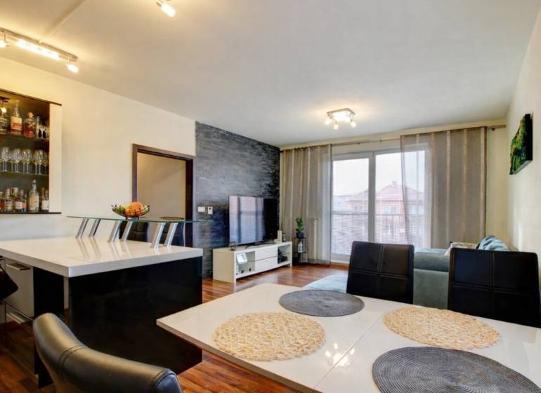 5-izb. byt, Krajinská, Podunajské Biskupice, 2.p./3 - Obývacia izba v 5 a viac izbovom byte s podlahou s dreveným dekorom a jedálenským stolom.