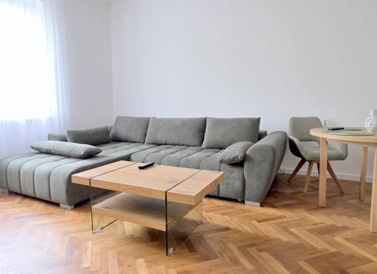 Pekný 3i byt, REKONŠTRUKCIA, KLÍMA, NIVY, Trenčianska ulica - Obývačka 3-izbového bytu ukazuje pohodlnú sedačku, stôl s kreslami na Trenčianskej ulici.