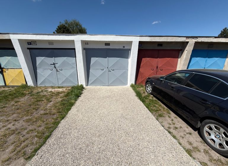 Na predaj kompletne zrekonštruovaná garáž v Trenčíne – ul. Bezručova - Garáže na Bezručovej ulici v Trenčíne s autom zaparkovaným vedľa na tráve.