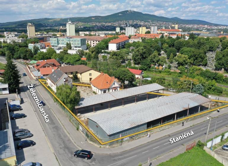 NA PRENÁJOM skladové priestory - areál v centre Nitry - Letecký pohľad na Železničiarsku ulicu v Nitre, Sklady a haly, okolité budovy a zeleň.