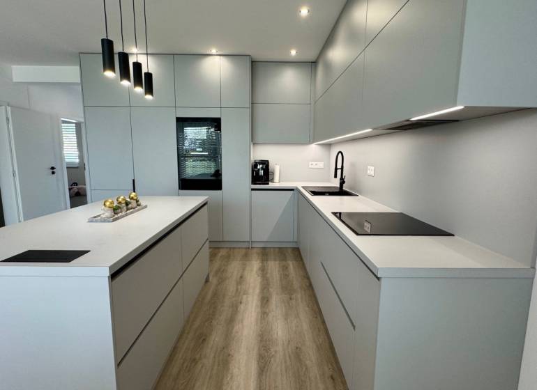 NA PREDAJ 4 izbový rodinný dom Štitáre NITRA - Sivá kuchyňa s ostrouhom, podlaha s dreveným dekorom, zabudované spotrebiče v Rodinnom dome.