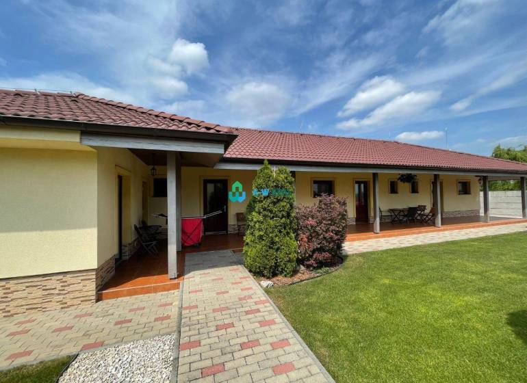 Apartmánový dom na predaj blízko termálneho kúpaliska - Na ulici neuvedené, vidno obchodné priestory s trávnikom a terasou.