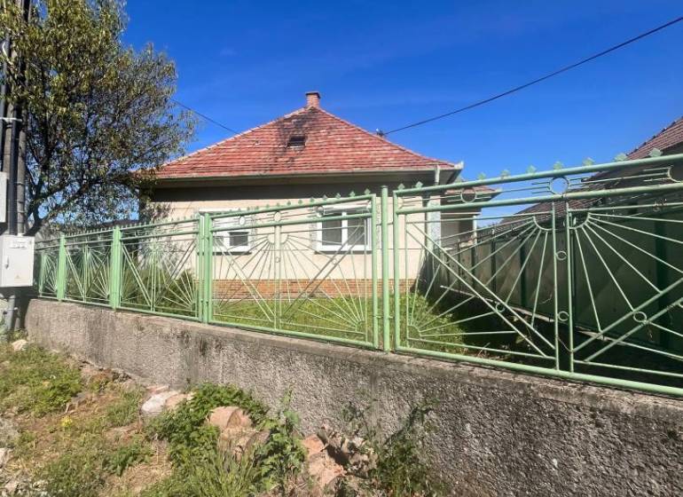 ☎️    0918 846 340    Rodinný dom okamžite obývateľný. - Rodinný dom v Lúči na Ostrove s červenou strechou a zeleným plotom z kovu.