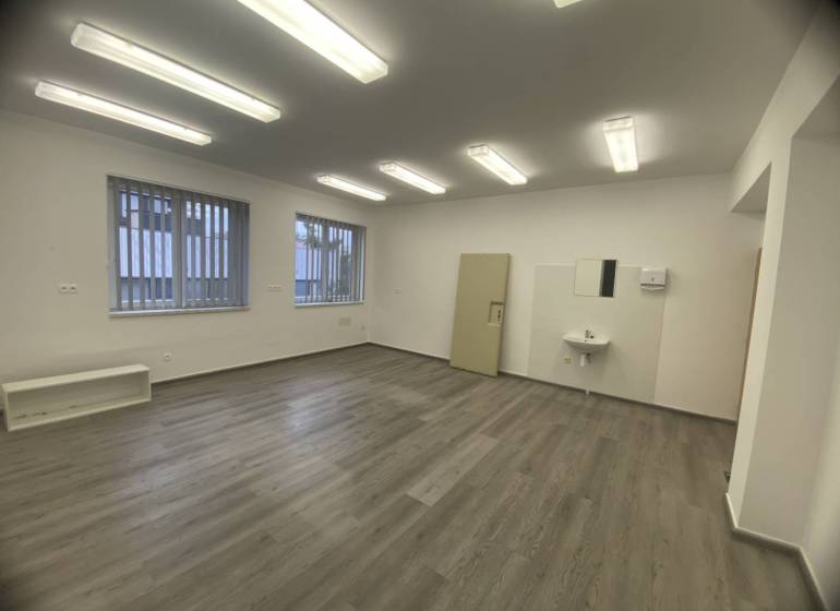 Skvelá ponuka!!! Prenájom nebytového priestoru na podnikateľské účely  - Izba v budove s podlahou s dreveným dekorom, umývadlom a žaluziami na oknách.