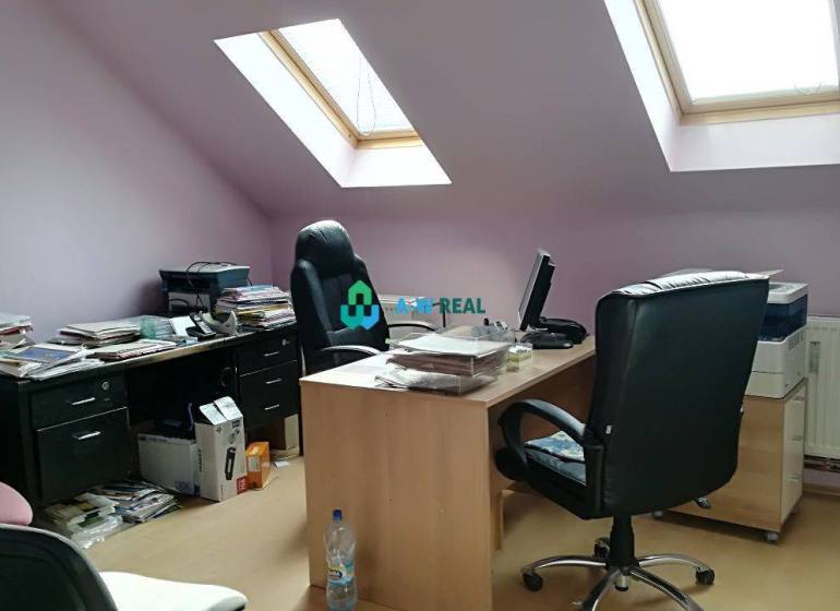 Kancelársky priestor s klimatizáciou na prenájom - Podkrovná kancelária so slnečným svetlom, na ulici neuvedené, vybavená pracovnými stolmi a šanónmi.
