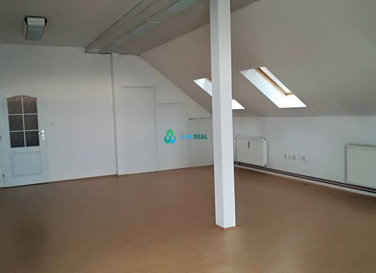 Kancelársky priestor na prenájom v Dunajskej Strede - Podkrovná kancelária s drevenou podlahou, strešnými oknami a bielymi stenami na ulici neuvedené.
