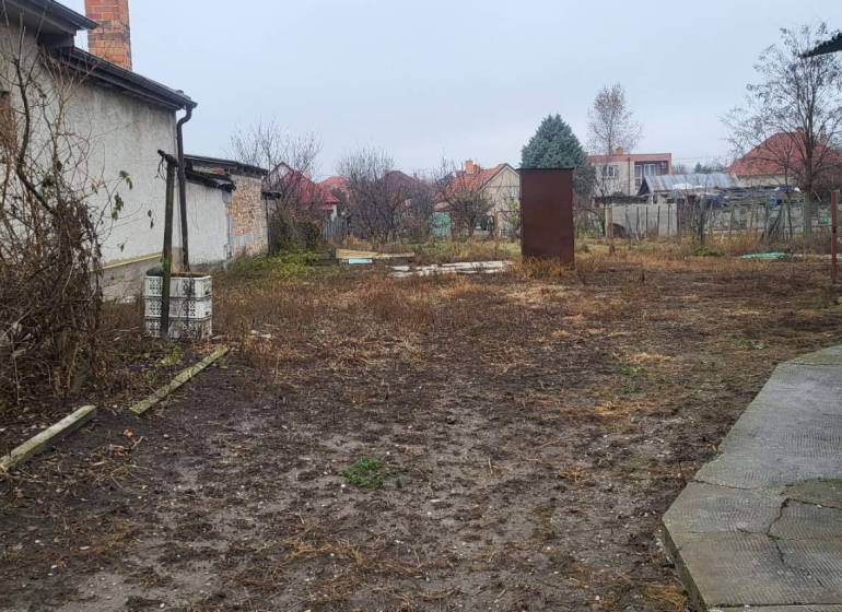 Na predaj starší rodinný dom v obci Ohrady - Záhrada rodinného domu v obci Ohrady, s neudržiavanou vegetáciou a nepoškodenými chodníkmi.