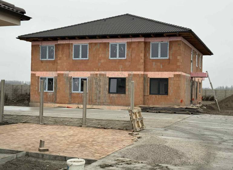 Nová štvorbytovka v tichom prostredí iba 10km od Dunajskej Stredy v ob - Rozostavaný dvojpodlažný dom v Padáňi s tehlovým exteriérom a nedokončeným dvorom.