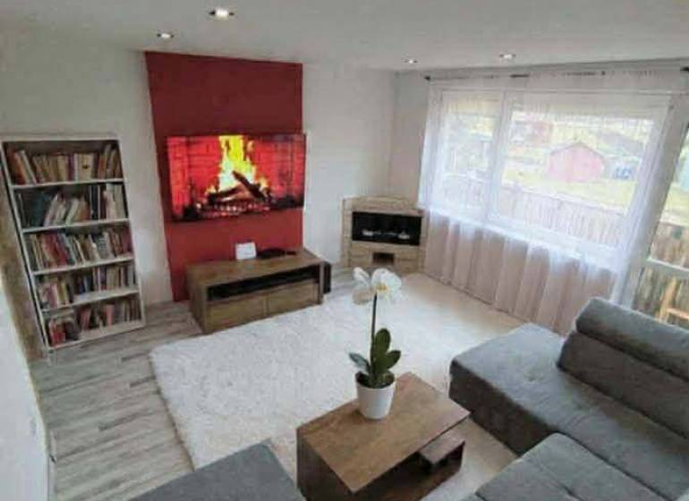 ☎️ 0918197701-Predám 3 izbový byt s loggiou po kompletnej rekonštrukci - Obývacia izba v 3-izbovom byte s podlahou s dreveným dekorom a pohodlnou sedačkou.