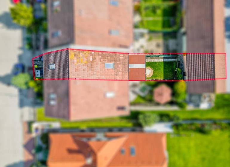 ☎️ 0918197701-Na predaj 5 izbový poschodový rodinný dom s 2 garážou v  - Letecký pohľad na rodinný dom v Dunajskej Strede so záhradou a okolitými strechami.