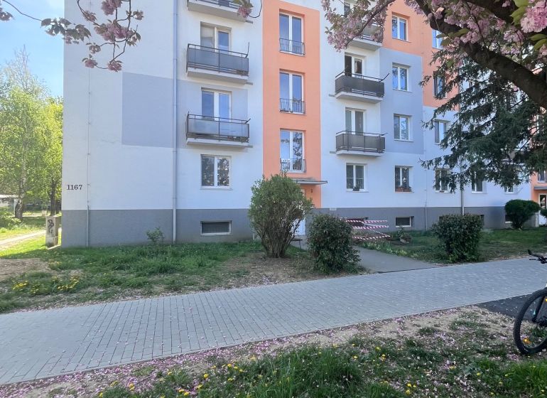 NA PREDAJ! 3i byt s 2 balkónmi - pôvodný stav, 69 m2, 28. októbra, TN - Budova na ulici 28. októbra v Trenčíne s rozkvitnutými čerešňovými stromami.