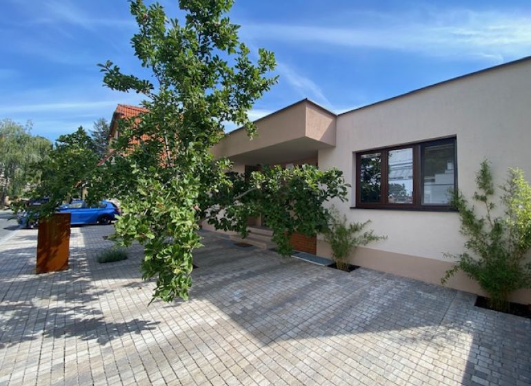 ,Prenájom moderný 3 izb. byt, Sološnícka ul,124 m2, Karlova Ves - Rodinný dom v Bratislave - Karlovej Vsi na Sološnickej ulici obklopujú stromy a dláždený chodník.