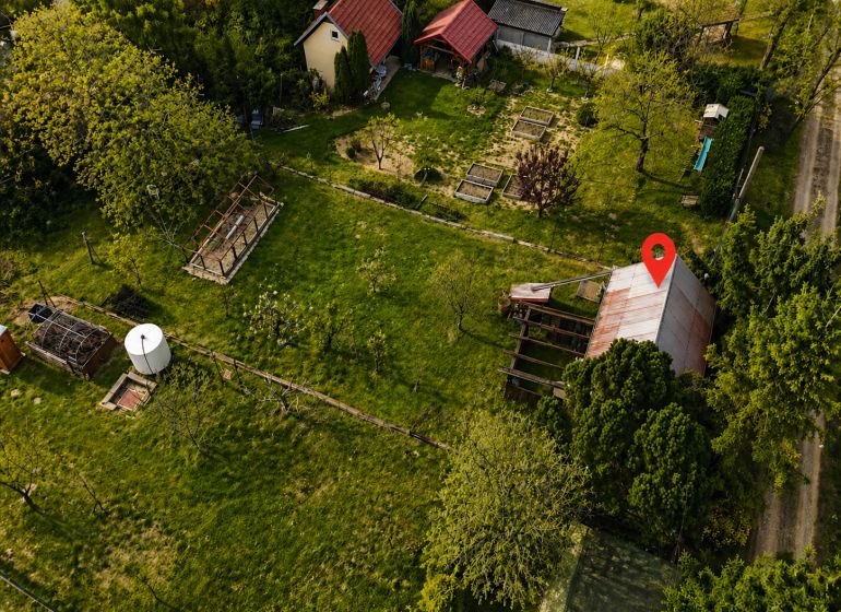 REZERVOVANÉ - Záhrada, ticho, vlastný priestor | pozemok s chatkou - Letecký pohľad na chatu na Mlynskej ulici v Báhoni, obklopenú zeleňou.