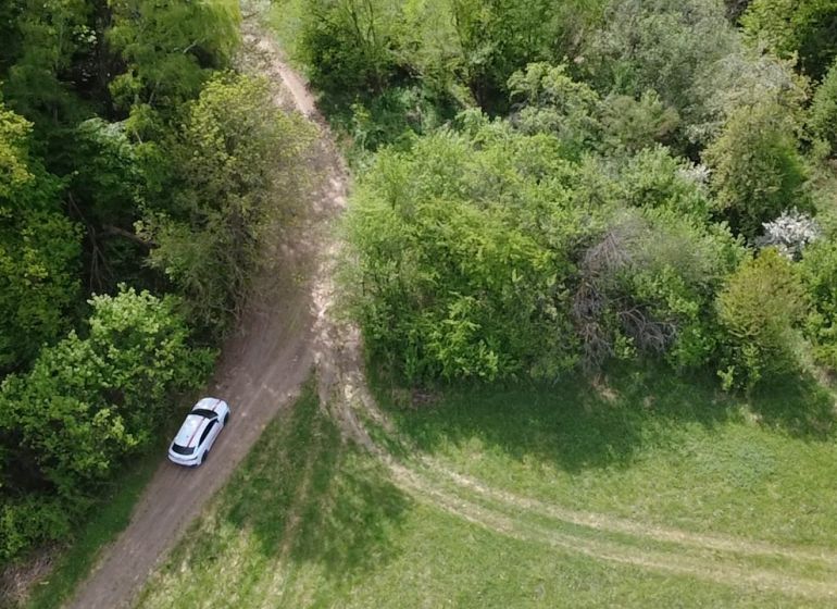 Pozemok vhodný na chov včiel Streženice- 874 m2 - Žena stojí pred rekreačnými pozemkami v Streženiciach, ideálnymi pre chov včiel.