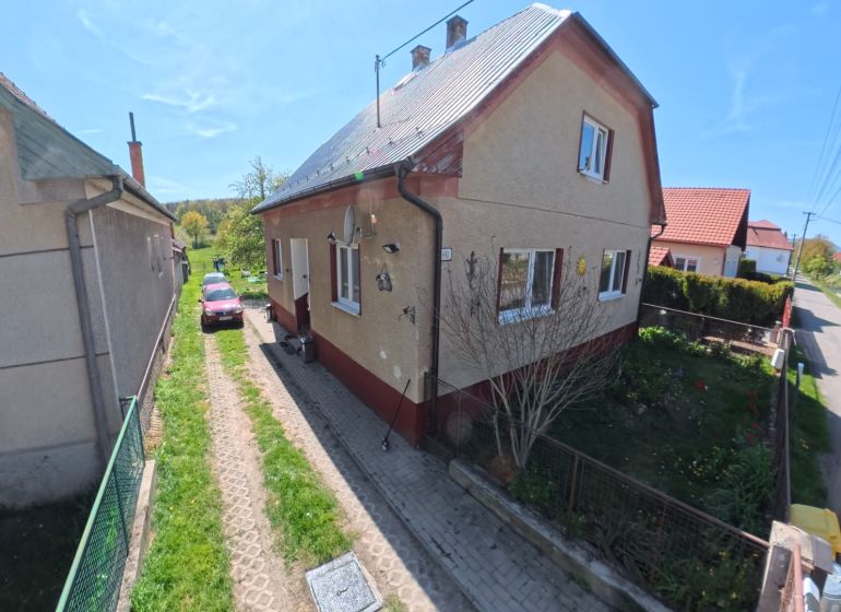 Dobré Reality ponúkajú rodinný dom s veľkou záhradou v obci Svinná  - Rodinný dom v Svinné s automobilom na príjazdovej ceste a udržiavanou záhradou.