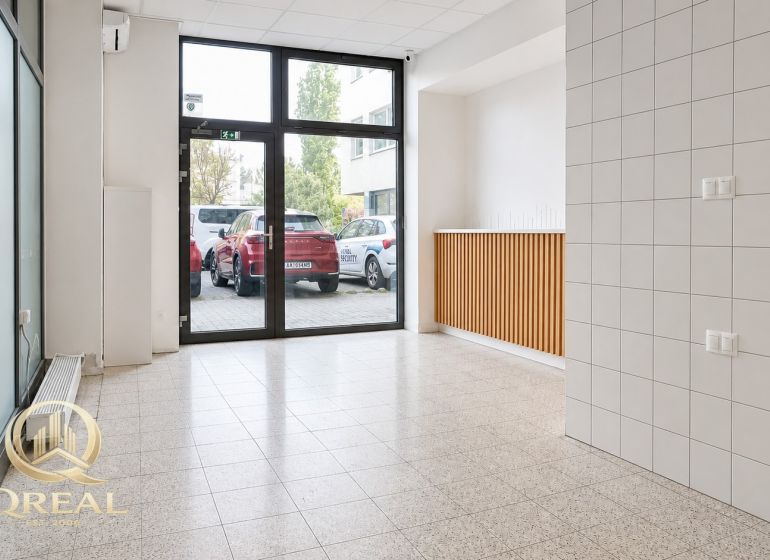 *Prenájom obchodného priestoru s výkladom, 26,3 m² – Račianske mýto* - Svetlá miestnosť s veľkými oknami a dlažbou, ideálna pre obchodné priestory.