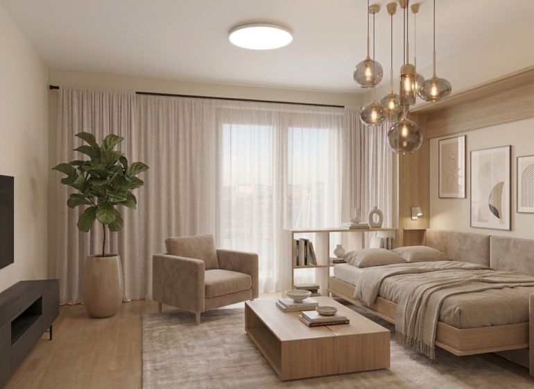 I Predaj Výnimočný  1-izb apartmán v projekte Metropolis - 1-izbový byt s pohovkou, posteľou, podlahou s dreveným dekorom a izbovou rastlinou.