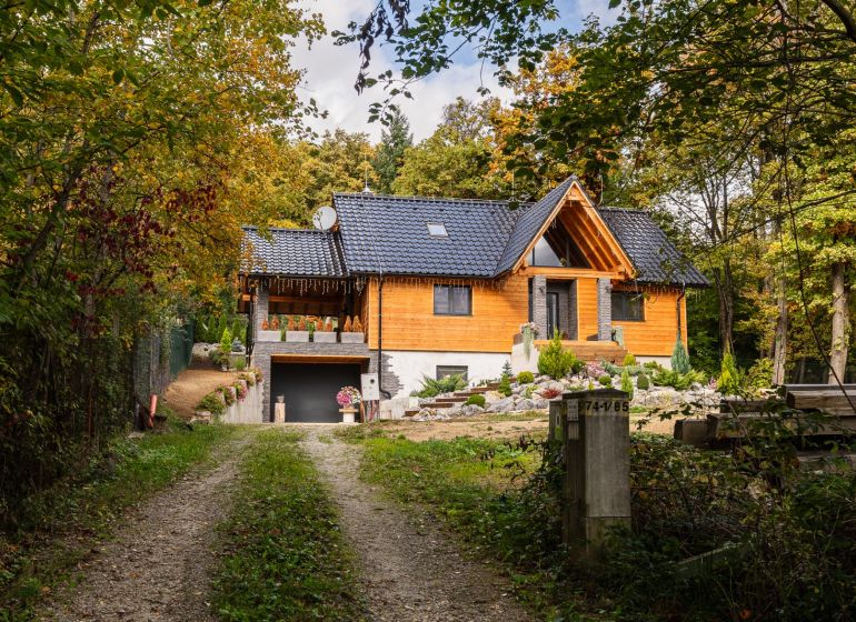 NA PREDAJ čarovná CHATA v srdci Duchonky - Topoľčany  - Chata v Prašiciach obklopená lesom, s dreveným obložením a čiernou strechou.