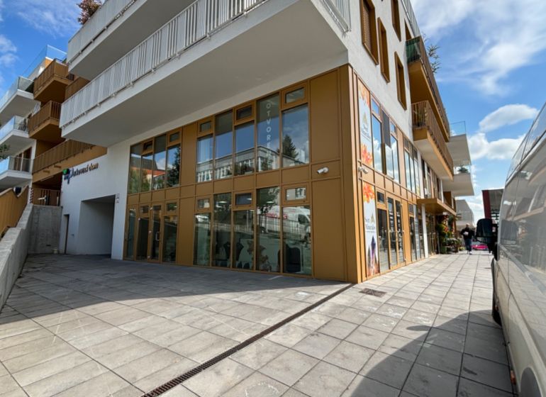 NA PRENÁJOM 2 izbový byt priamo v centre Nitry  - Budova na Piaristickej ulici v Nitre s veľkými oknami, modernou architektúrou a parkovacím miestom.