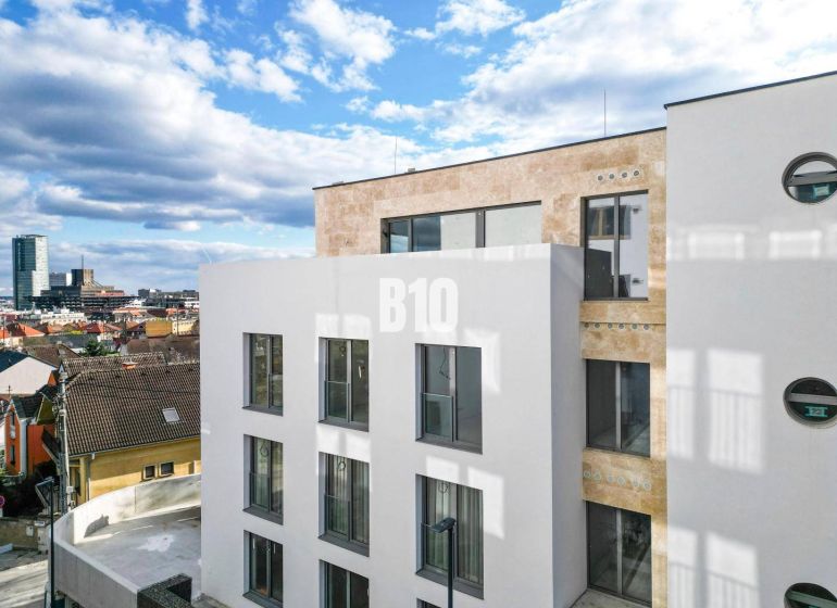 POD VINICAMI - 3IZBOVÉ BYTY V NADŠTANDARDNEJ BOUTIQUE REZIDENCII - Biela budova s veľkými oknami v Bratislave III na Matúškovej so 3-izbovým bytom.