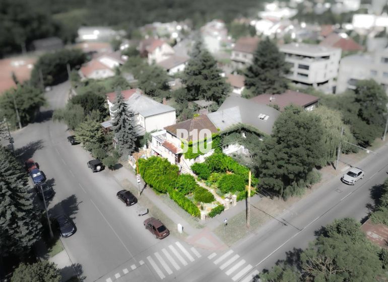 Rodinný dom s príbehom na výnimočnom mieste – Gaštanová ulica - Rodinný dom v lokalite Bratislava - Staré Mesto, obklopený zeleňou a cestou s autami.
