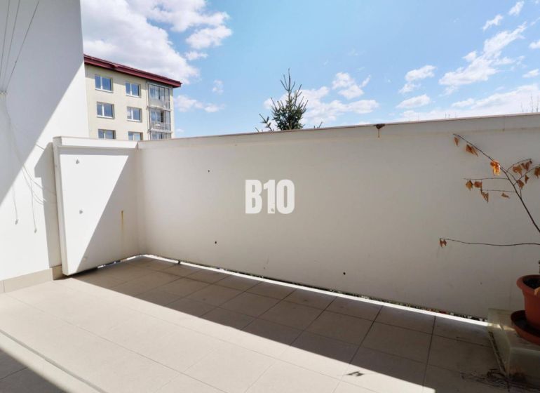 3 izbový byt SEVER, výborná ulica - Balkón v 3-izbovom byte. Rastlina v kvetináči, dlažba, čiastočný výhľad na susednú budovu.