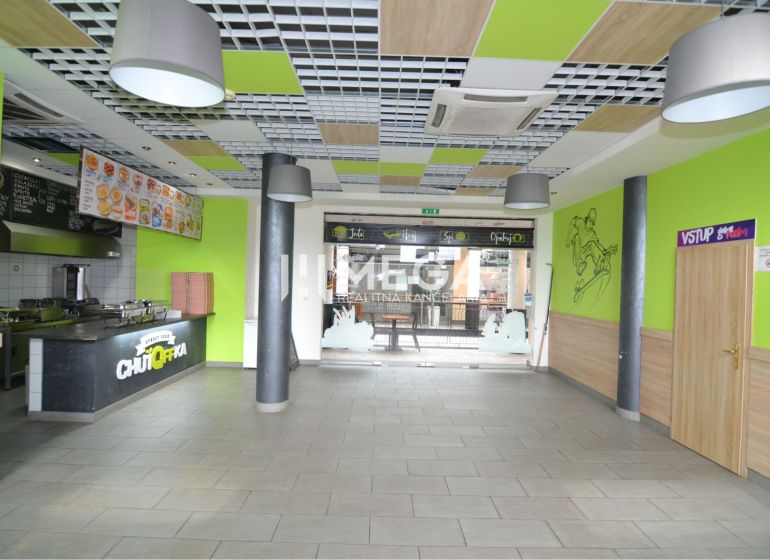 NA PRENÁJOM TOP GASTRO PRIESTOR NA PRENÁJOM – BEZ DEPOZITU - Obchodné priestory s jedálenským pultom, podlaha s dreveným dekorom, pestré interiérové prvky.