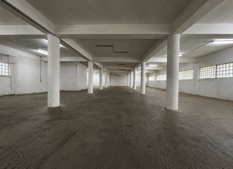 Na  prenájom vykurovaný sklad s nakladacou rampou, 540 m² - Zvolen - Priestranný interiér s betónovou podlahou a bielymi stĺpmi v skladoch a halách.