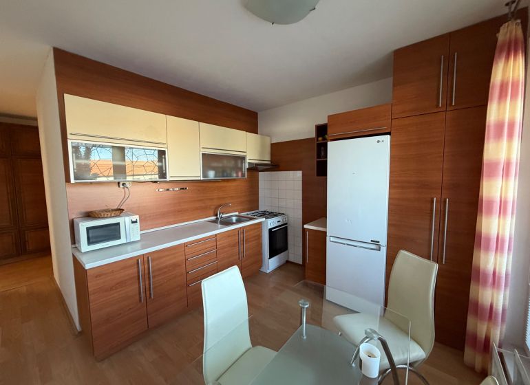 3 izbový byt s balkónom v meste Levice - Kuchyňa v 3-izbovom byte s dreveným dekorom a moderným zariadením.