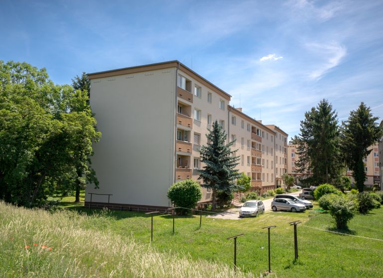 TOP LOKALITA - 3i 67m2 + loggia - Švermova Trenčín - Bytové domy na ulici Švermova v Trenčíne s okolitou zeleňou a zaparkovanými autami.