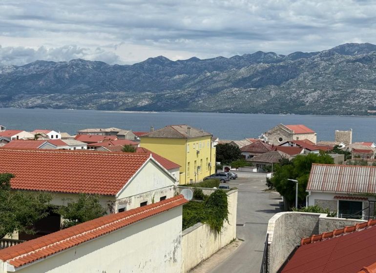 CHORVÁTSKO - Novo zariadený rodinný dom - RAŽANAC - Výhľad na pobrežie a hory v Ražanaci z rodinného domu s červenými strechami.