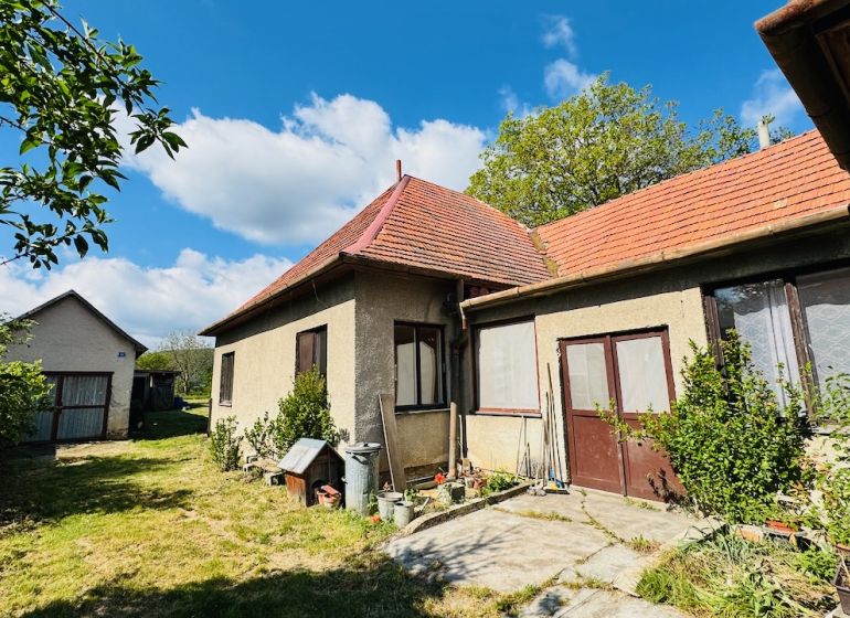 Na predaj 6-izbový rodinný dom (dvojdom) v Pažiti, pozemok 1445 m² - Rodinný dom v Pažiti s červenou strechou a prechodom do záhrady.