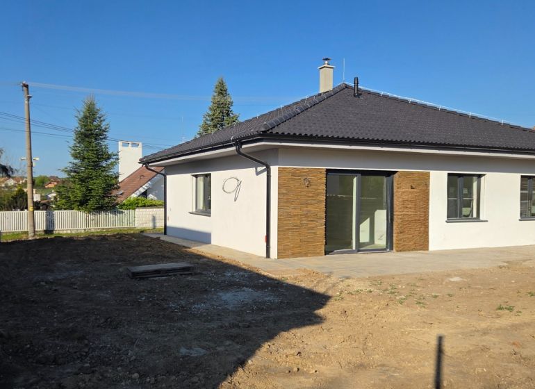 Bungalov v centre obce Cabaj Čápor, Wágnerova ulica, Dom č.1 - Rodinný dom v Cabaj-Čápore s bielou fasádou a šikmou strechou.
