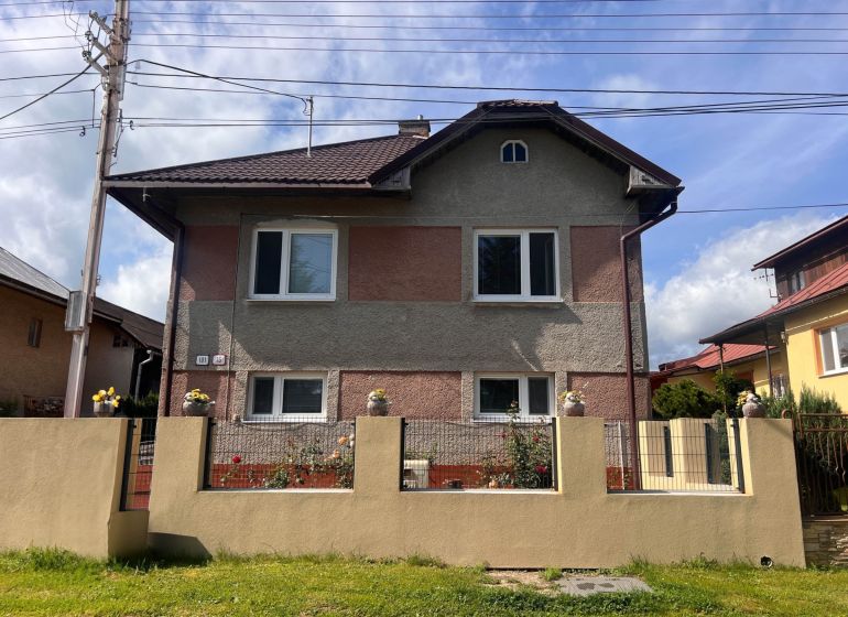 Rodinný dom Bacúch – rekonštrukcia. - Rodinný dom v Bacúchu obklopený záhradou a oplotením pod modrou oblohou.