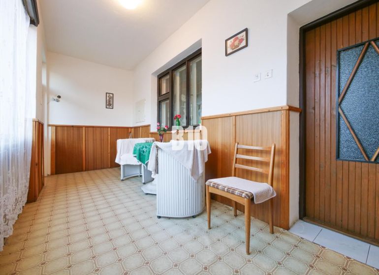 Útulný rodinný dom v príjemnej lokalite - Chodba v Rodinnom dome so stoličkou a stolom, obloženie stenami z dreva.