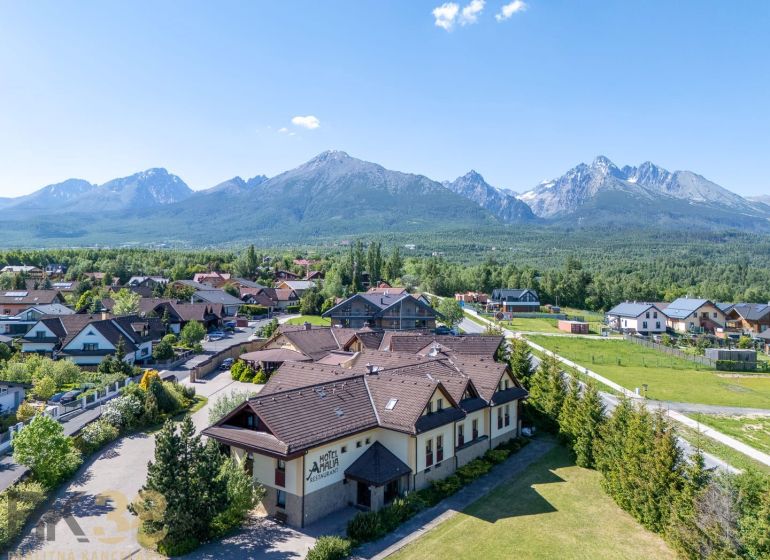NA PREDAJ: Zabehnutý hotel Amália s wellnesom v srdci Vysokých Tatier - Pohľad na Hotely a penzióny v Novej Lesnej s panorámou Tatier.