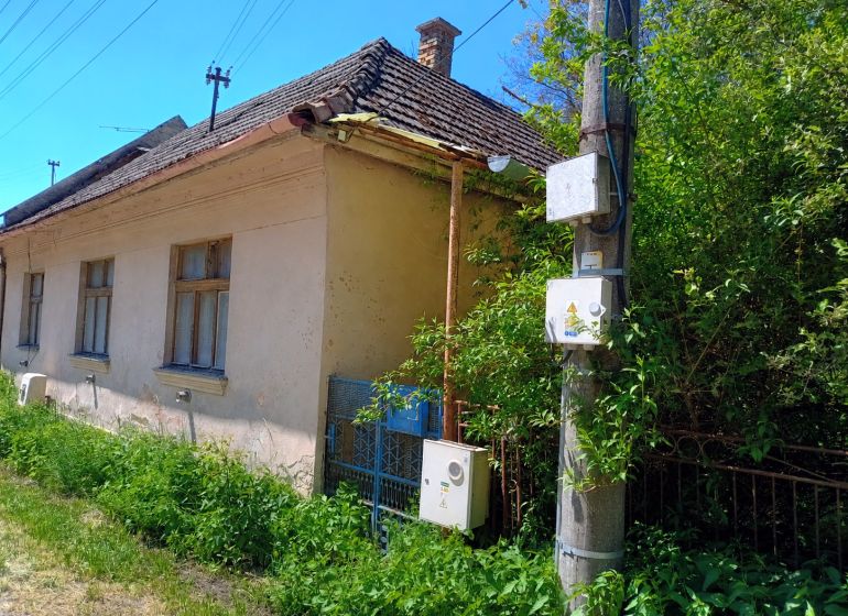 Rodinný dom s pozemkom 4282m2 KĽAČNO okr. Prievidza, - Rodinný dom v Kľačne s klesajúcou škridlovou strechou a bujnou vegetáciou okolo.
