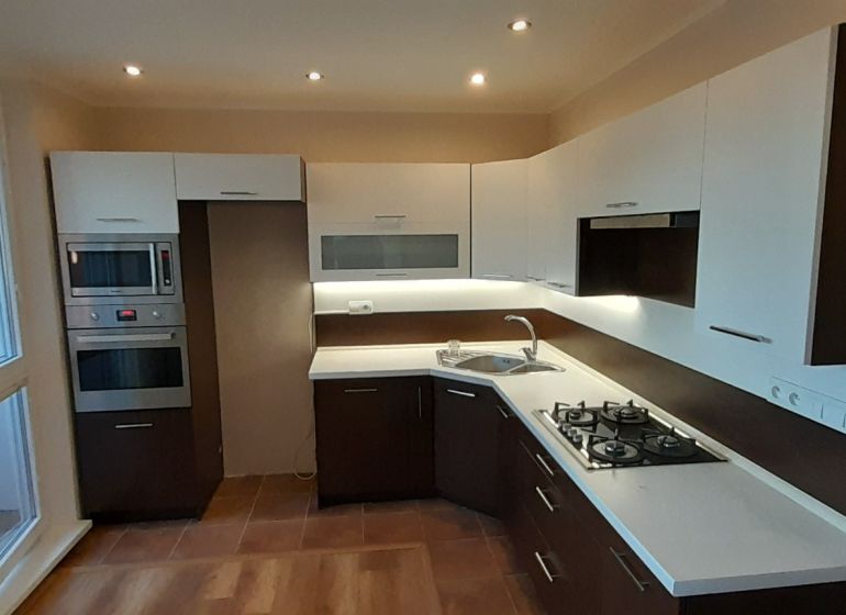 Pekný 2 izbový byt s balkónom na prenájom. - Kuchyňa v 2-izbovom byte s podlahou s dreveným dekorom a zabudovanými spotrebičmi.