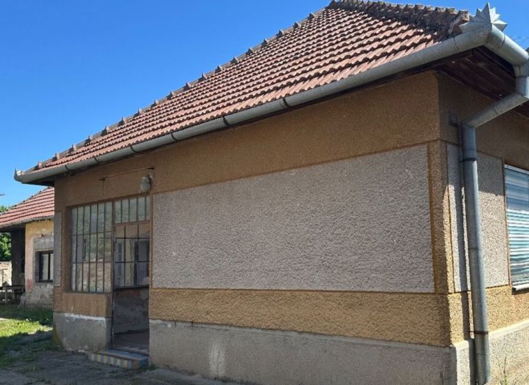 Na predaj rodinný dom s veľkým pozemkom v tichej lokalite - Rodinný dom v Močenku s šikmou strechou a presklenými dverami na slnečnom dvore.